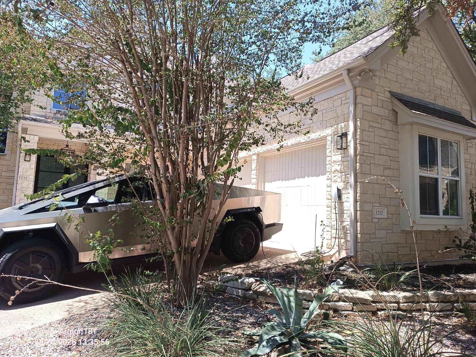 Cybertruck parked beside a residential garage