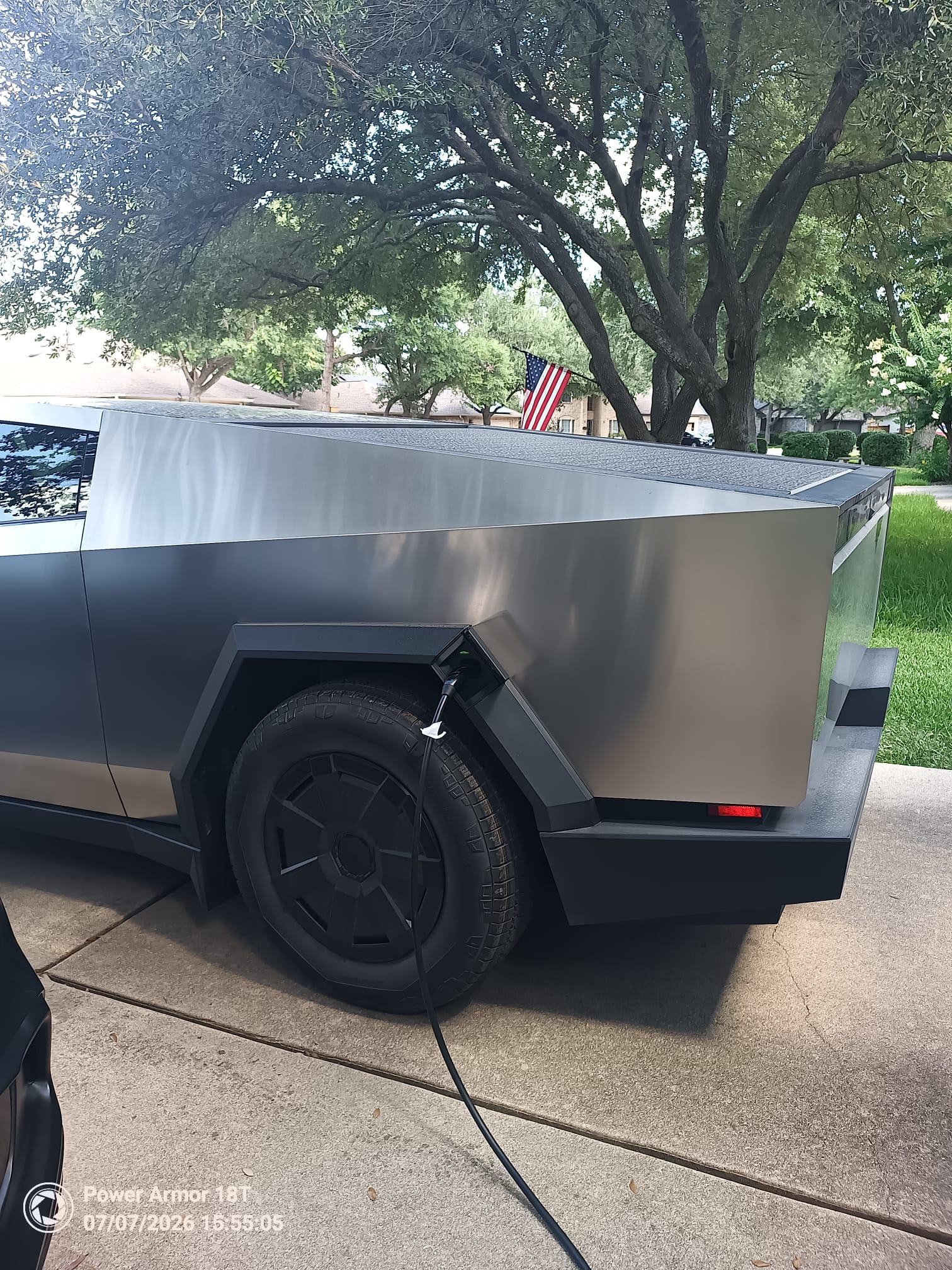 Cybertruck with a charging connector attached at home