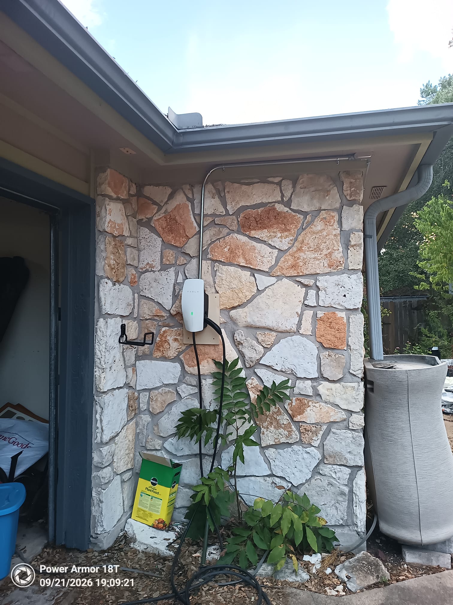 Exterior Tesla Wall Connector installation on a stone wall